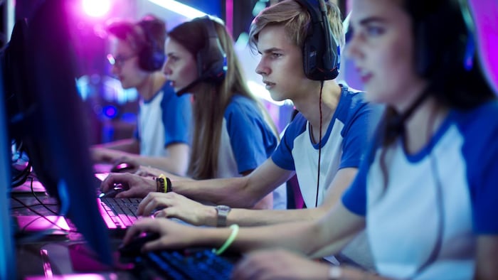 两个女孩和两个男孩组成的团队正在电脑上玩。